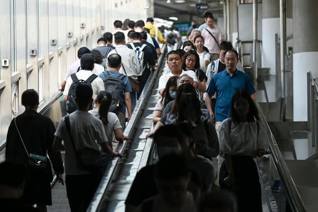 Los pasajeros utilizan las escaleras mecánicas en una estación de metro de Pekín el 10 de julio de 2024. (Wang Zhao/AFP vía Getty Images)