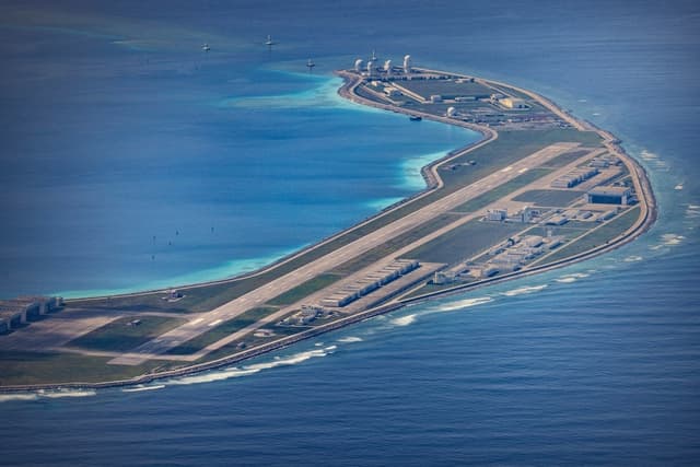 En la imagen, tomada el 25 de octubre de 2022, se observan un aeródromo, edificios y estructuras en la isla artificial construida por China en el Arrecife Mischief, en las Islas Spratly, en el Mar de China Meridional. (Ezra Acayan/Getty Images)