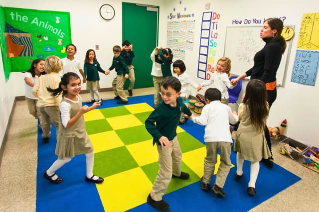Una maestra de la escuela Mandell dirige a los niños en un juego de canto en la ciudad de Nueva York, el 11 de diciembre de 2012. (The Epoch Times).