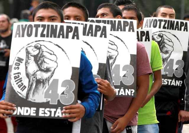 Fotografía de archivo del 26 de septiembre de 2017 de personas protestando durante la marcha del tercer aniversario de la desaparición de los 43 jóvenes estudiantes de Ayotzinapa, en Ciudad de México (EFE/ Mario Guzmán)
