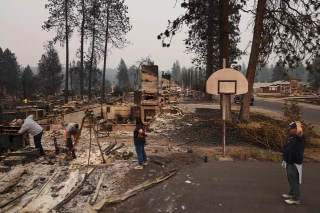La gente evalúa los daños causados por un incendio en una vivienda en Spokane, Washington, el 3 de agosto de 2026. (Lindsey Wasson/AP Photo)