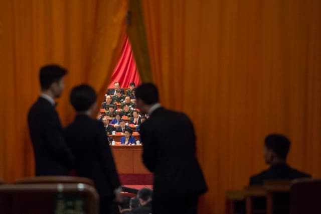 Guardias de seguridad chinos observan a los delegados militares durante el discurso del líder chino Xi Jinping en el XIX Congreso del Partido Comunista, celebrado en Beijing el 18 de octubre de 2017. (Fred Dufour/AFP vía Getty Images)