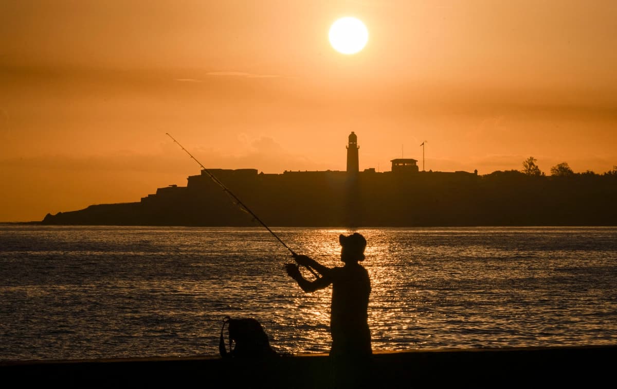 Silueta de un pescador con el faro del Morro al fondo durante un apagón al amanecer en La Habana, el 29 de junio de 2026. (Yamil Lage/AFP vía Getty Images)