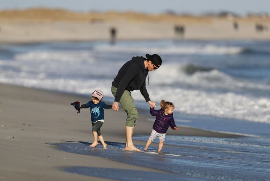 Imagen ilustrativa: Un padre jugando con sus dos hijos en la playal (Al Bello/Getty Images)