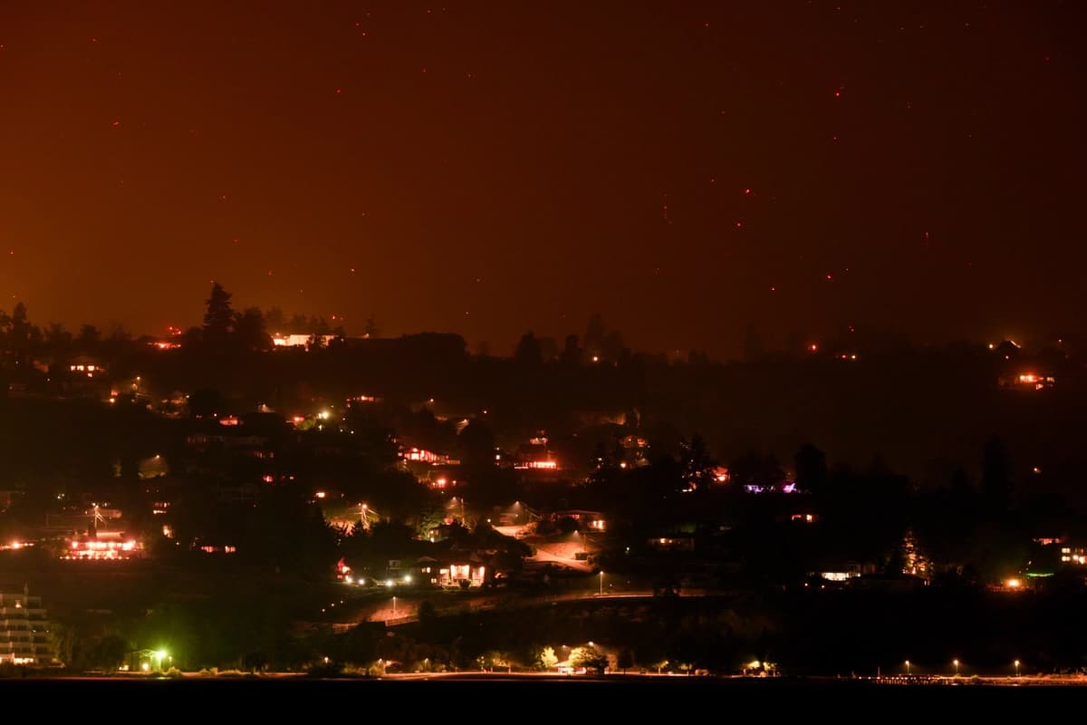 Los focos de incendio del Bald Range, que ha obligado a 20,000 personas a abandonar sus hogares en la región sur de Okanagan, arden en la ladera de la montaña sobre las casas, en Summerland, Columbia Británica, a última hora del 8 de agosto de 2026. (The Canadian Press/Darryl Dyck).