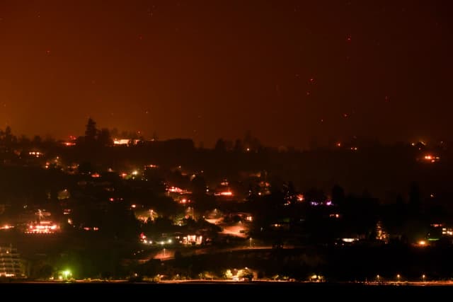 Los focos de incendio del Bald Range, que ha obligado a 20,000 personas a abandonar sus hogares en la región sur de Okanagan, arden en la ladera de la montaña sobre las casas, en Summerland, Columbia Británica, a última hora del 8 de agosto de 2026. (The Canadian Press/Darryl Dyck).