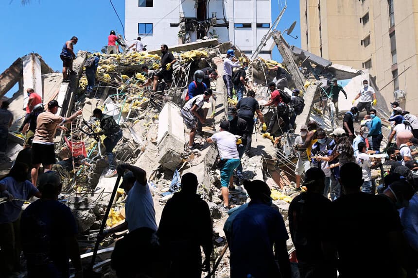 La gente busca sobrevivientes entre los escombros de un edificio derrumbado tras un terremoto en Cali, Colombia, el 10 de agosto de 2026. (Joaquín SARMIENTO / AFP vía Getty Images)