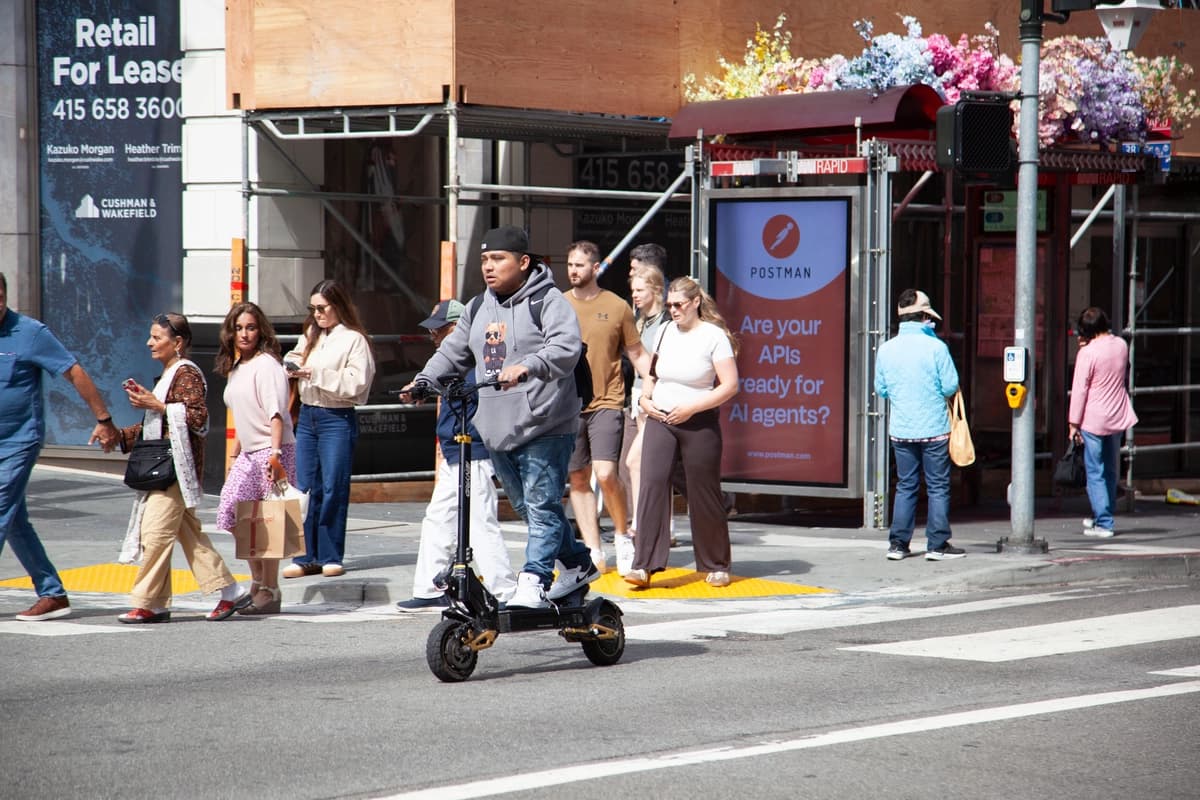 Un hombre cruza una intersección cerca de Union Square en San Francisco en un patinete eléctrico el 7 de agosto de 2026. (Lear Zhou/The Epoch Times).