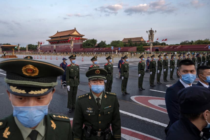 Agentes de policía y personal de seguridad controlan a la multitud tras una ceremonia oficial de izamiento de bandera cerca de la Plaza de Tiananmén y la Ciudad Prohibida en Beijing, el 1 de octubre de 2021. (Kevin Frayer/Getty Images).