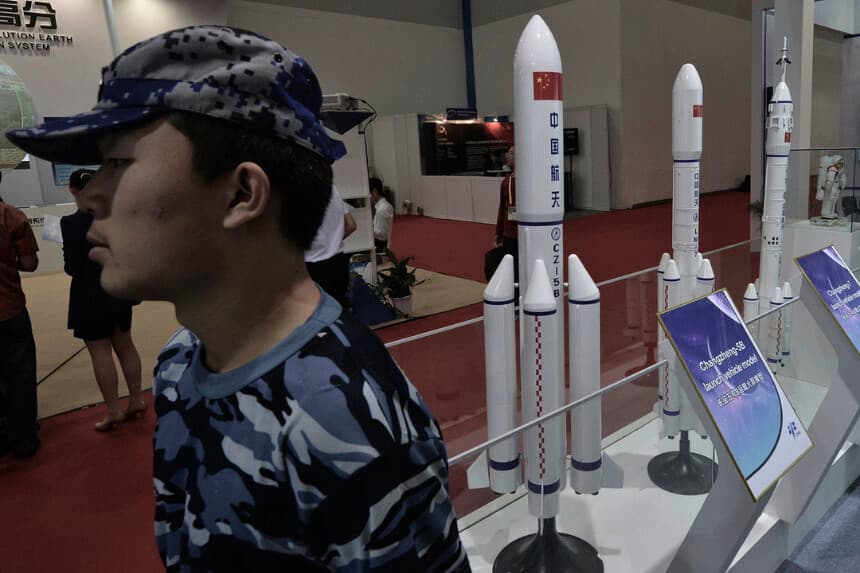 Un guardia de seguridad se encuentra junto a modelos de cohetes chinos expuestos en el 64º Congreso Internacional de Astronáutica en Pekín el 24 de septiembre de 2013. (Mark Ralston/AFP/Getty Images).