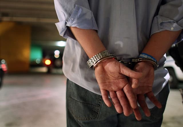 Foto ilustrativa: Hombre esposado por autoridades de EE. UU. en Florida (Joe Raedle/Getty Images)