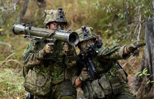 Soldados de la Fuerza Terrestre de Autodefensa de Japón (JGSDF) participan en una operación de limpieza de un aeródromo en Townsville, Australia, el 10 de junio de 2026. (Ian Hitchcock/Getty Images)
