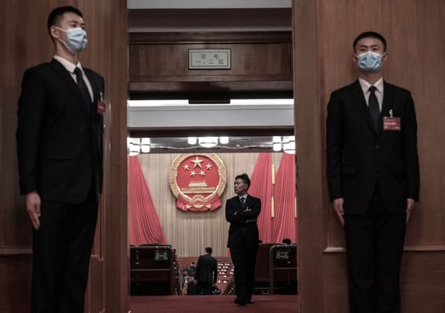 Personal de seguridad en la entrada mientras un delegado ingresa al auditorio antes de la apertura de la Asamblea Popular Nacional en el Gran Salón del Pueblo, en Beijing, China, el 5 de marzo de 2024. (Kevin Frayer/Getty Images)