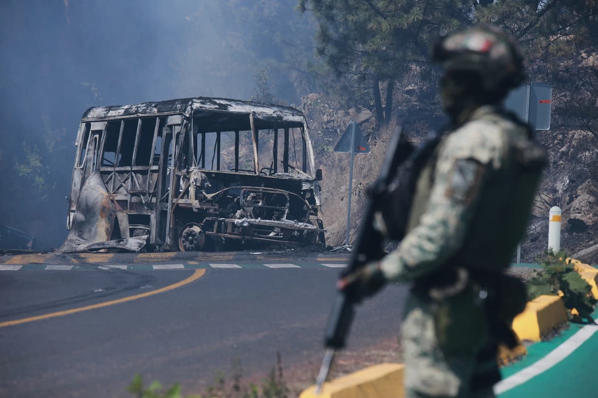 Un soldado monta guardia junto a un vehículo calcinado tras ser incendiado, luego de la muerte del líder del CJNG, en Cointzio, estado de Michoacán, México, el 22 de febrero de 2026. (Armando Solis/AP).