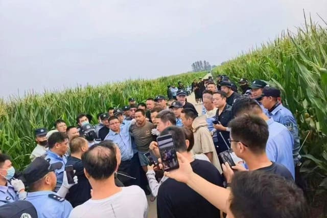 Xia Fugang (el hombre con barba que lleva una camiseta gris en el centro de la foto, a quien un oficial de policía con lentes sujeta por el cuello) es detenido por la policía en la localidad de Kongzhongguo, ciudad de Luohe, provincia de Henan, China, el 8 de agosto de 2026. (Cortesía del entrevistado).