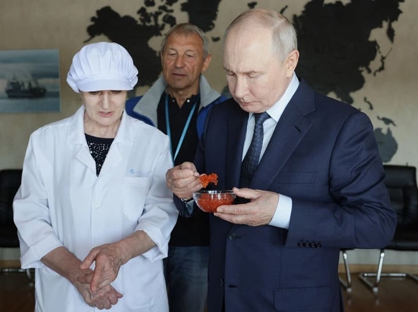 El presidente ruso, Vladimir Putin (derecha), prueba huevas de pescado durante su visita a la planta procesadora de pescado Yasny en la isla de Iturup, una de las cuatro islas del archipiélago en disputa conocido como las islas Kuriles en Rusia y los Territorios del Norte en Japón, el 13 de agosto de 2026. (Gavriil Grigorov/AFP vía Getty Images)