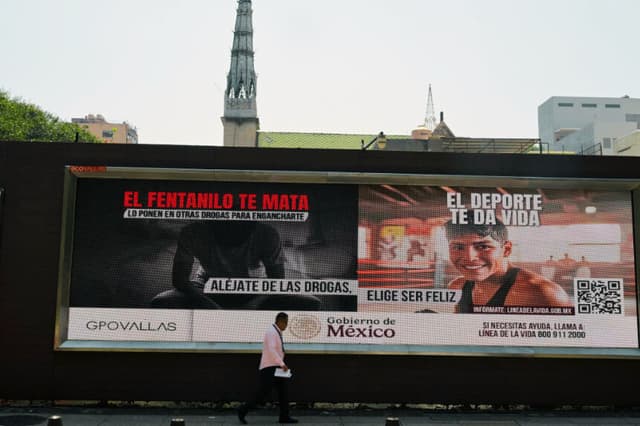 Un peatón pasa junto a unas vallas publicitarias que muestran una campaña lanzada por la presidenta de México, Claudia Sheinbaum, contra el consumo de fentanilo en la Ciudad de México, el 10 de marzo de 2025. (ALFREDO ESTRELLA/AFP vía Getty Images)