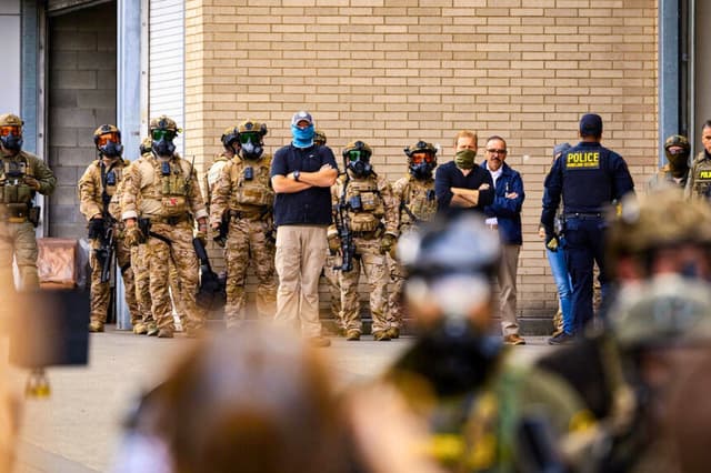 Agentes federales vigilan a los manifestantes frente a las oficinas de Inmigración y Control de Aduanas en Portland, Oregón, el 4 de octubre de 2025. (John Fredricks/The Epoch Times).