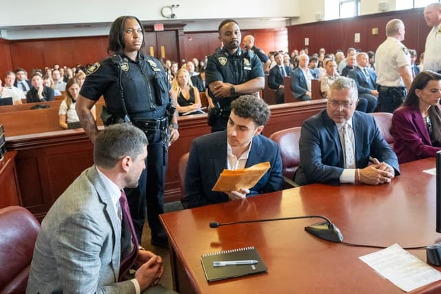 Luigi Mangione (C) conversa con su abogado Jacob Kaplan (I) durante su comparecencia ante la Corte Suprema de Manhattan, en la ciudad de Nueva York, el 17 de junio de 2026. (Steven Hirsch/Pool/Getty Images)