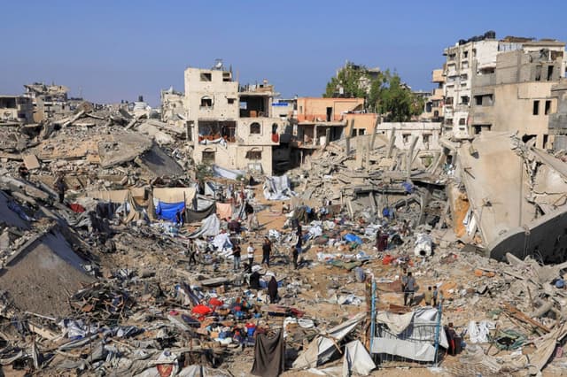 Los palestinos inspeccionan el lugar del ataque israelí del miércoles contra una casa cuyos residentes fueron advertidos previamente por el ejército israelí de evacuar, en la ciudad de Gaza, el 30 de julio de 2026. (REUTERS/Dawoud Abu Alkas).