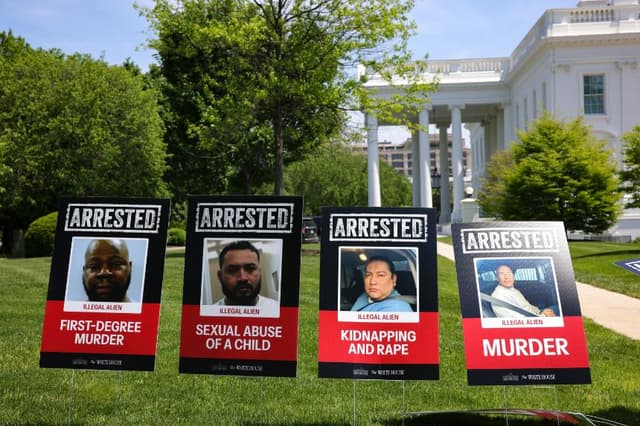 El 29 de abril de 2025, en el Jardín Norte de la Casa Blanca, en Washington, D.C., cerca de una zona designada para la prensa, se exhiben carteles con imágenes de inmigrantes ilegales detenidos que habían cometido delitos. (BRYAN DOZIER/Middle East Images/AFP vía Getty Images)