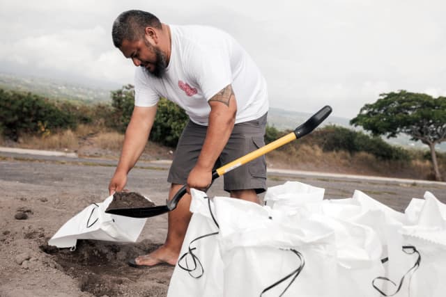 Casey Delaries prepara un saco de arena para la tormenta tropical Lala en Kailua-Kona, Hawái, el 14 de agosto de 2026. Se pronostica que la tormenta tropical se intensificará hasta convertirse en huracán a medida que se acerque a Hawái, con posibles precipitaciones de hasta 63,5 cm en la isla, también conocida como la Isla Grande. (Stephen Lam/San Francisco Chronicle vía AP).