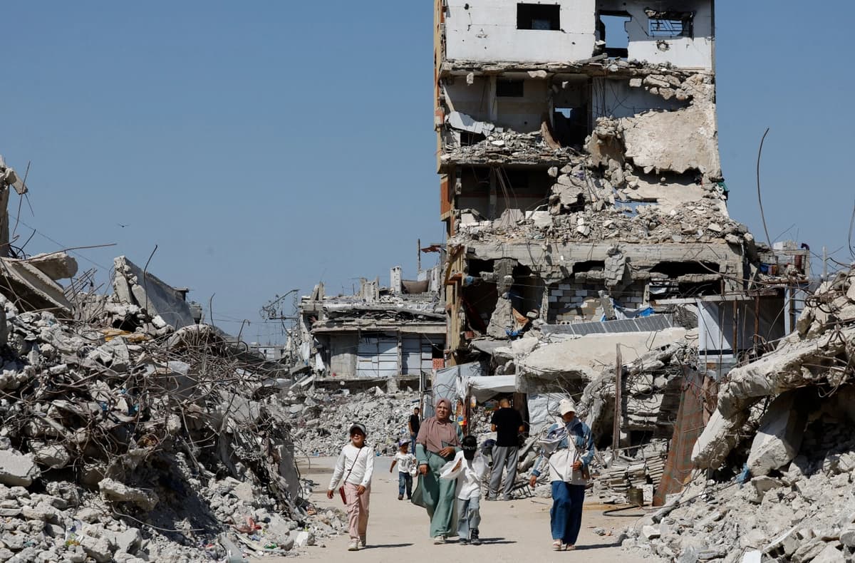 Los palestinos pasan junto a los escombros de edificios residenciales destruidos durante la guerra, en el campamento de refugiados de Jabalia, en el norte de la Franja de Gaza, el 5 de agosto de 2026. (Mahmoud Issa/Reuters)