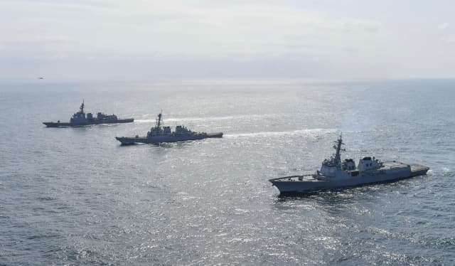 El destructor Yulgok Yi I (derecha) de la Armada de Corea del Sur, el USS Benfold (centro) de la Armada de EE. UU. y el JS Atago (izquierda) de la Fuerza de Autodefensa Marítima de Japón navegan en formación durante un ejercicio naval conjunto en aguas internacionales en un lugar no revelado el 17 de abril de 2023. (Ministerio de Defensa de Corea del Sur vía Getty Images)