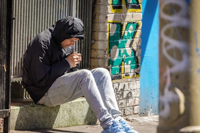 Un hombre consume drogas en el distrito de Tenderloin de San Francisco el 16 de mayo de 2024. (John Fredricks/The Epoch Times).