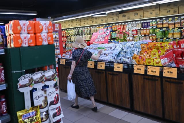 Un cliente selecciona un producto en un supermercado de Beijing el 17 de agosto de 2026. (Pedro Pardo/AFP vía Getty Images).