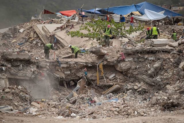 Personas remueven escombros de un edificio colapsado por los terremotos del 24 junio, este domingo en La Guaira, Venezuela. (EFE/ Ronald Peña R)