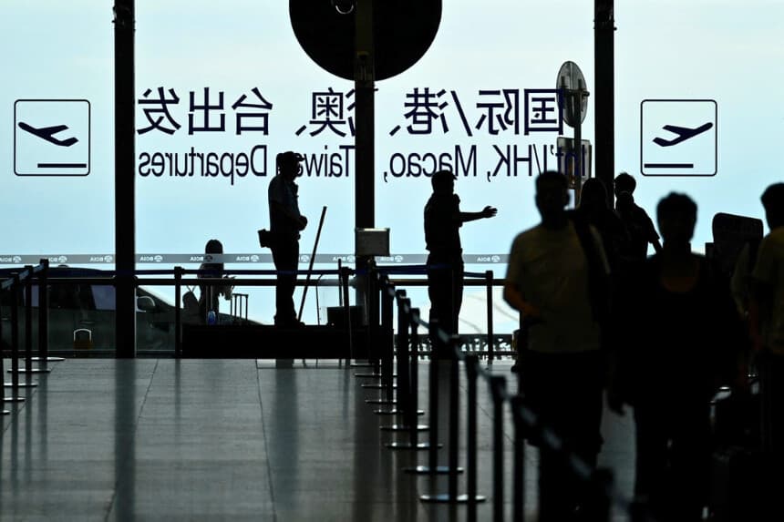 Un guardia de seguridad guía a los pasajeros en el Aeropuerto Internacional de Beijing Capital el 6 de julio de 2025. (Wang Zhao/AFP vía Getty Images).