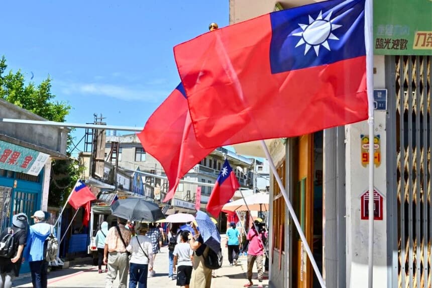 Banderas taiwanesas ondeando en un carril de una calle mientras turistas pasean por las islas Kinmen de Taiwán, el 11 de agosto de 2022. (Sam Yeh/AFP vía Getty Images).