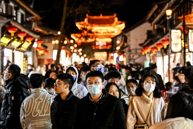 Personas caminando en el pueblo de Dali, una división administrativa de nivel municipal en la ciudad de Dali, en la provincia china de Yunnan, el 14 de enero de 2023. (Noel Celis/AFP vía Getty Images).