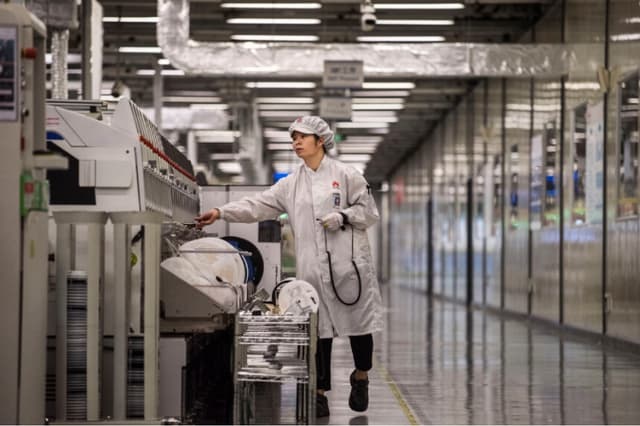 Una trabajadora empaqueta nuevos teléfonos inteligentes al final de la línea de producción en el campus de producción de Huawei en la ciudad de Dongguan, provincia de Guangdong, China, el 11 de abril de 2019. (Kevin Frayer/Getty Images).