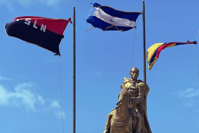 Vista del monumento a Simón Bolívar, flanqueado por las banderas de Nicaragua, Venezuela y el Frente Sandinista de Liberación Nacional (FSLN), en el Malecón de Managua, a orillas del lago Xolotlán, en Managua, el 28 de junio de 2026. (AFP vía Getty Images)