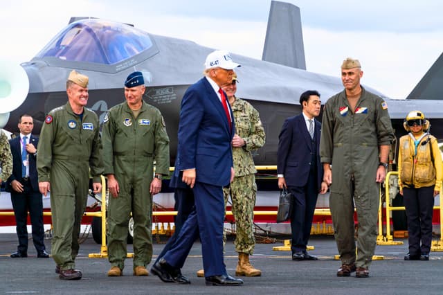 El presidente Donald Trump camina por la cubierta de vuelo del portaaviones clase Nimitz USS George Washington (CVN 73) durante una visita presidencial mientras el buque se encontraba atracado en el muelle de la Base Naval de Yokosuka, el 28 de octubre de 2025. Durante su visita, Trump se reunió con líderes estadounidenses y japoneses, condecoró a marineros y se dirigió a la tripulación del buque. El George Washington es el principal portaaviones de la Armada de los Estados Unidos desplegado en el exterior, un símbolo de larga data del compromiso de Estados Unidos con el mantenimiento de una región indopacífica libre y abierta, al tiempo que opera junto a aliados y socios en toda la flota numerada más grande de la Armada de los Estados Unidos. (Foto de la Armada de los Estados Unidos tomada por la especialista en comunicación de masas de tercera clase Ana Souza Young).