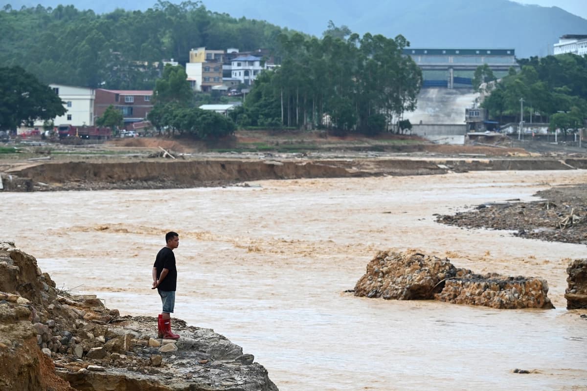 Un hombre observa el agua que fluye del embalse colapsado de Liulan en la aldea de Liulan, en la ciudad de Hengzhou, región de Guangxi, al suroeste de China, el 8 de julio de 2026. (Greg Baker/AFP vía Getty Images)