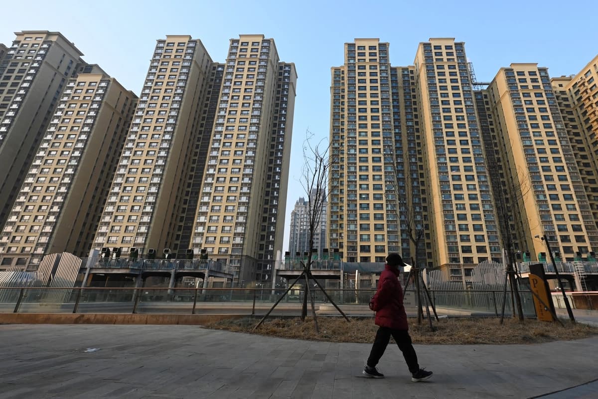 Una mujer pasa junto a un complejo residencial del Grupo Evergrande llamado Evergrande Palace en Beijing el 29 de enero de 2024. (Greg Baker/AFP vía Getty Images)