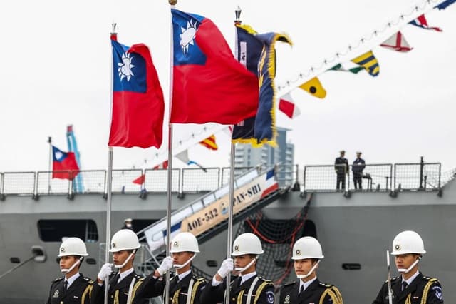 Guardias de honor de la República de China, Taiwán, portan banderas taiwanesas durante una jornada de puertas abiertas al público en el puerto de Keelung el 17 de marzo de 2025. (I-haw Cheng /AFP vía Getty Images)