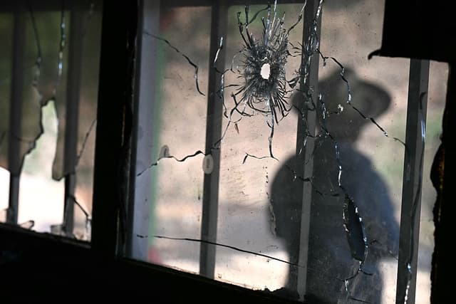 Se ve la silueta, detrás de un agujero de bala en la fachada de la comisaría de Tula, en el municipio de Chilapa de Álvarez, estado de Guerrero, México, el 19 de mayo de 2026, (YURI CORTEZ / AFP vía Getty Images)