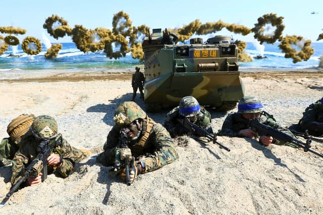 Los Marines estadounidenses y surcoreanos toman posiciones tras desembarcar en la playa durante el ejercicio militar conjunto Ssangyong, en Pohang, Corea del Sur, el 12 de marzo de 2016. (Kim Jun-bum/Yonhap vía AP)