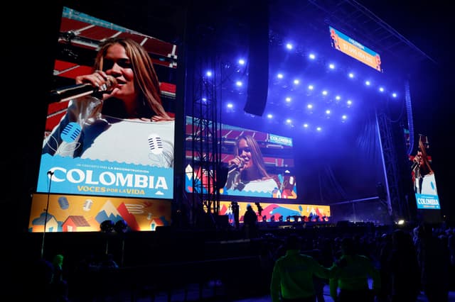 La cantante colombiana Karol G (en pantalla) se presenta en el concierto 'Voces por la vida' este domingo, en la recaudación de fondos para la reconstrucción de la zonas afectadas por el terremoto de magnitud 7.4 que sacudió a Colombia, en Bogotá (EFE/ Carlos Ortega)