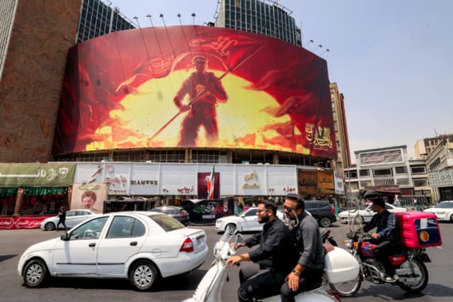 Automovilistas pasan junto a una valla publicitaria política en la plaza Valiasr, en el centro de Teherán, Irán, el 8 de agosto de 2026. (Atta Kenare/AFP vía Getty Images).