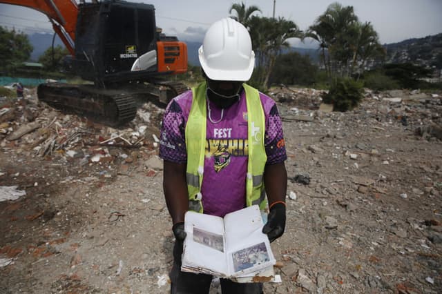 Una obrero fue captado este 25 de agosto al mostrar un álbum familiar de fotografías hallado entre los escombros de edificios colapsados tras el terremoto de magnitud 7.4 que azotó a Colombia el pasado 10 de agosto, en Cali, Colombia. (EFE/Ernesto Guzmán)