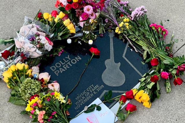 Ramos de flores y tarjetas que los fans llevaron a la estrella de Dolly Parton en el Paseo de la Fama de Music City tras su fallecimiento, en Nashville, el 25 de agosto de 2026. (Jacki Thrapp/The Epoch Times).