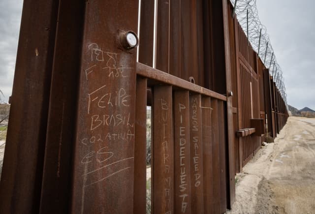 Escritos dejados por inmigrantes indocumentados se encuentran en una sección del muro fronterizo de Estados Unidos a las afueras de Jacumba, California, el 21 de enero de 2026. (John Fredricks/The Epoch Times)