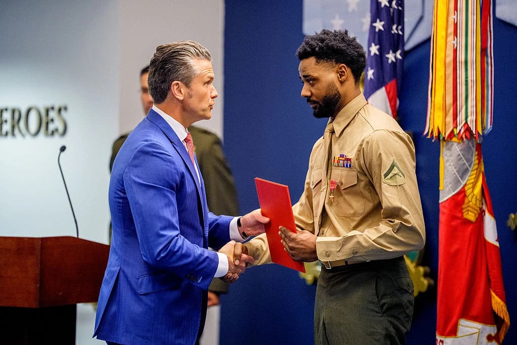 El secretario de Guerra, Pete Hegseth (izquierda), le da la mano al teniente coronel de la Infantería de Marina Jordan Houston (derecha) durante un evento para honrar a los marines que prestaban servicio durante el atentado con bomba de Abbey Gate de 2021, en el Pentágono, en Arlington, Virginia, el 26 de agosto de 2026. A tres marines estadounidenses de la Compañía Golf se les elevó formalmente el nivel de sus condecoraciones al valor para honrar su heroísmo y sus acciones que salvaron vidas durante el atentado de Abbey Gate de 2021, en el Aeropuerto Internacional Hamid Karzai de Kabul. (Andrew Harnik/Getty Images)