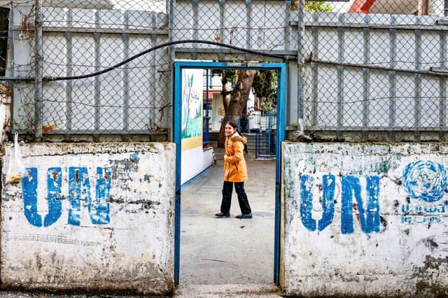 Una niña se encuentra en el patio de un edificio de la Agencia de las Naciones Unidas para los Refugiados de Palestina (UNRWA) en el campamento de Askar para refugiados palestinos, al este de Nablus, en la Cisjordania ocupada por Israel, el 31 de diciembre de 2025. (Zain Jaafar/AFP vía Getty Images).