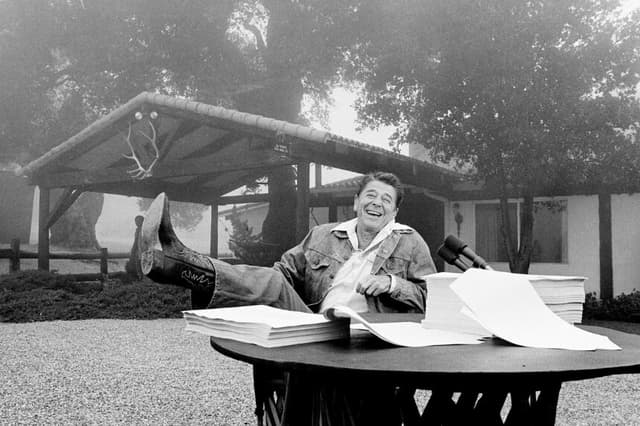 El presidente Ronald Reagan muestra su bota tras la firma de su ley fiscal en su casa de vacaciones de California, Rancho del Cielo, cerca de Santa Bárbara Calif., el 13 de agosto de 1981. (Foto de AP).